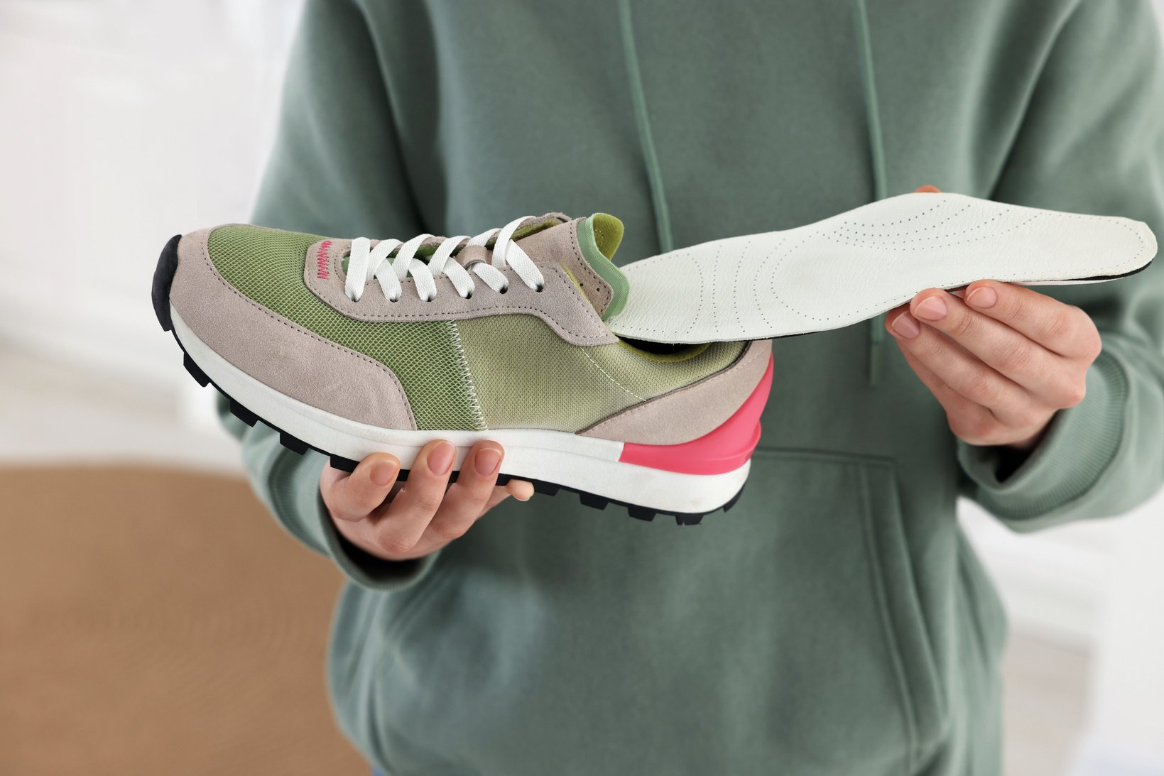 Woman Putting Orthopedic Insole into Shoe Indoors, Closeup. Foot